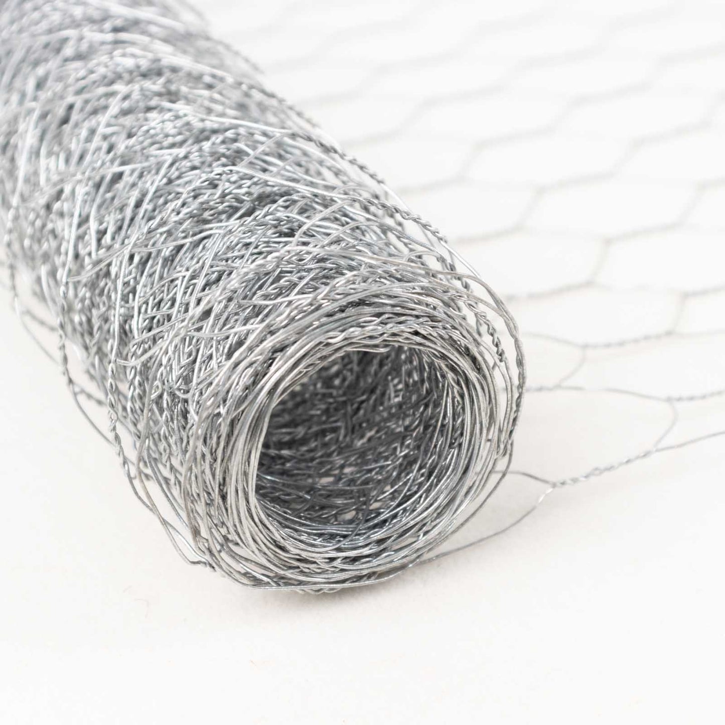 Silver galvanized metal hexagonal chicken wire mesh roll for DIY crafts and garden fencing.