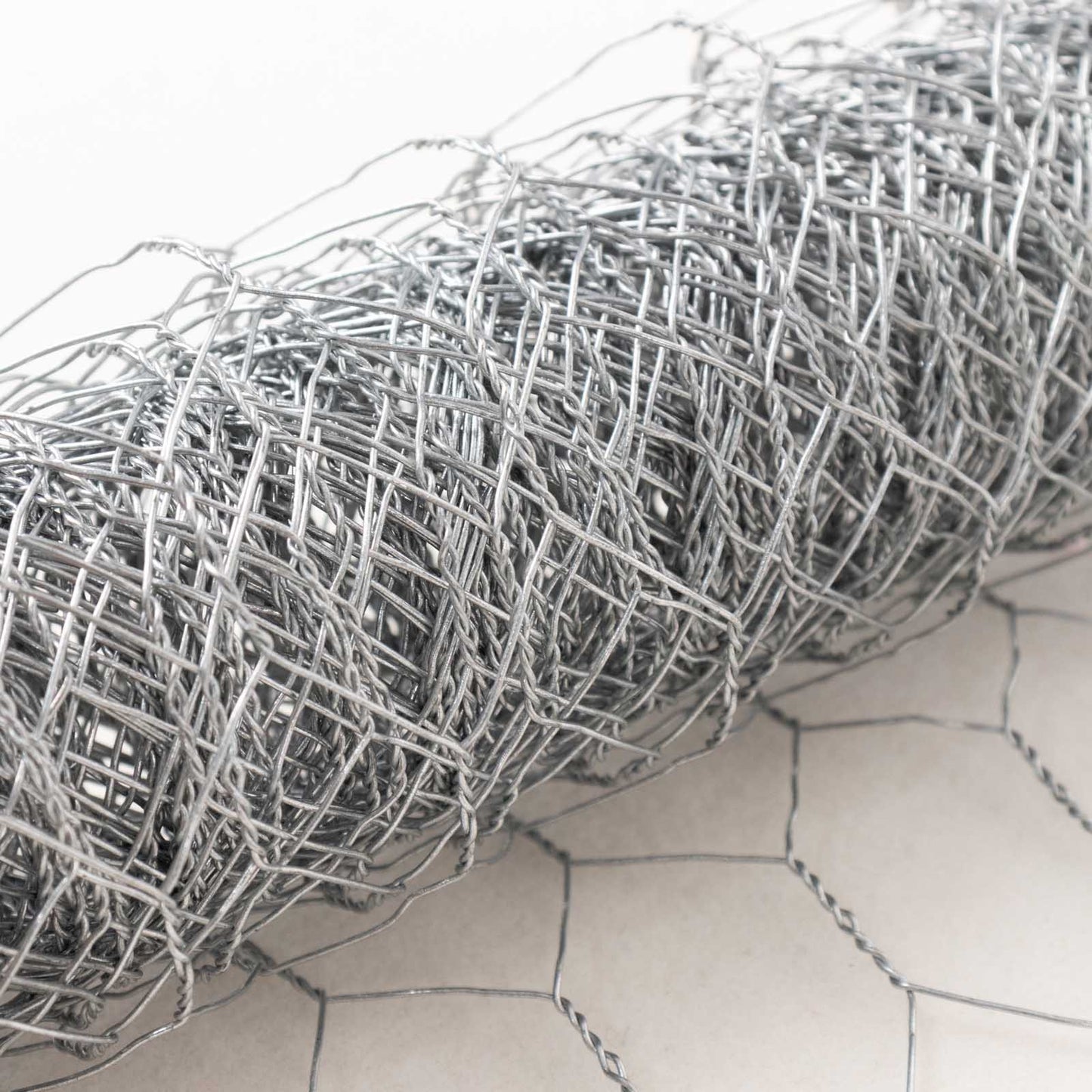 Silver galvanized hexagonal chicken wire mesh for crafts and garden fencing.