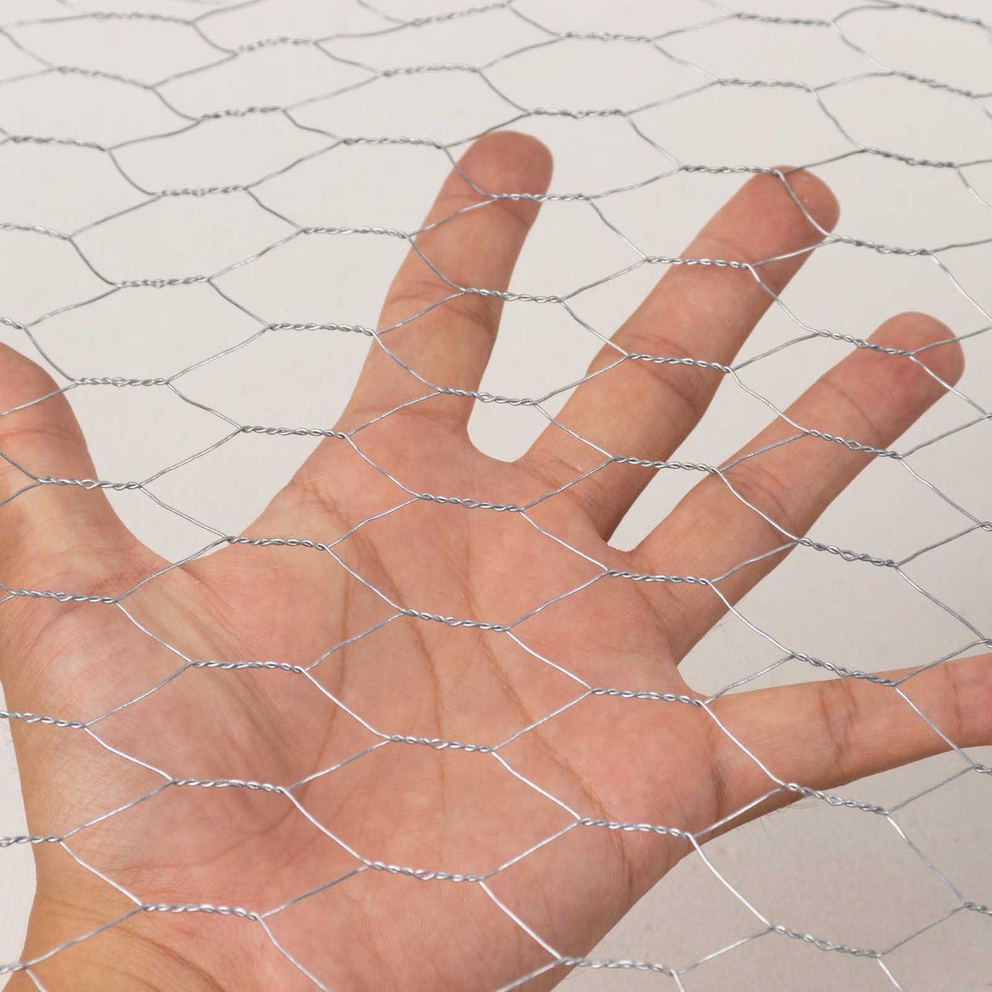 Silver galvanized metal hexagonal chicken wire mesh for DIY crafts and garden fencing.