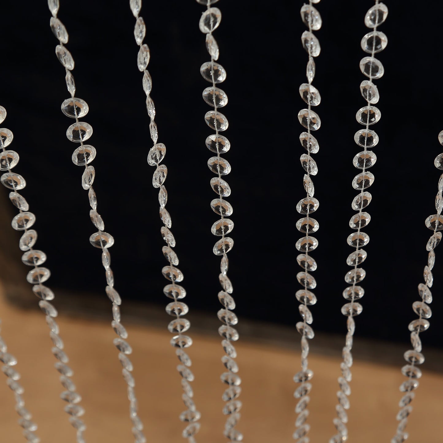 Clear acrylic beaded curtain with diamond cut beads for doorway decoration.