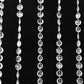 Clear acrylic crystal beaded curtain strands on a black background.