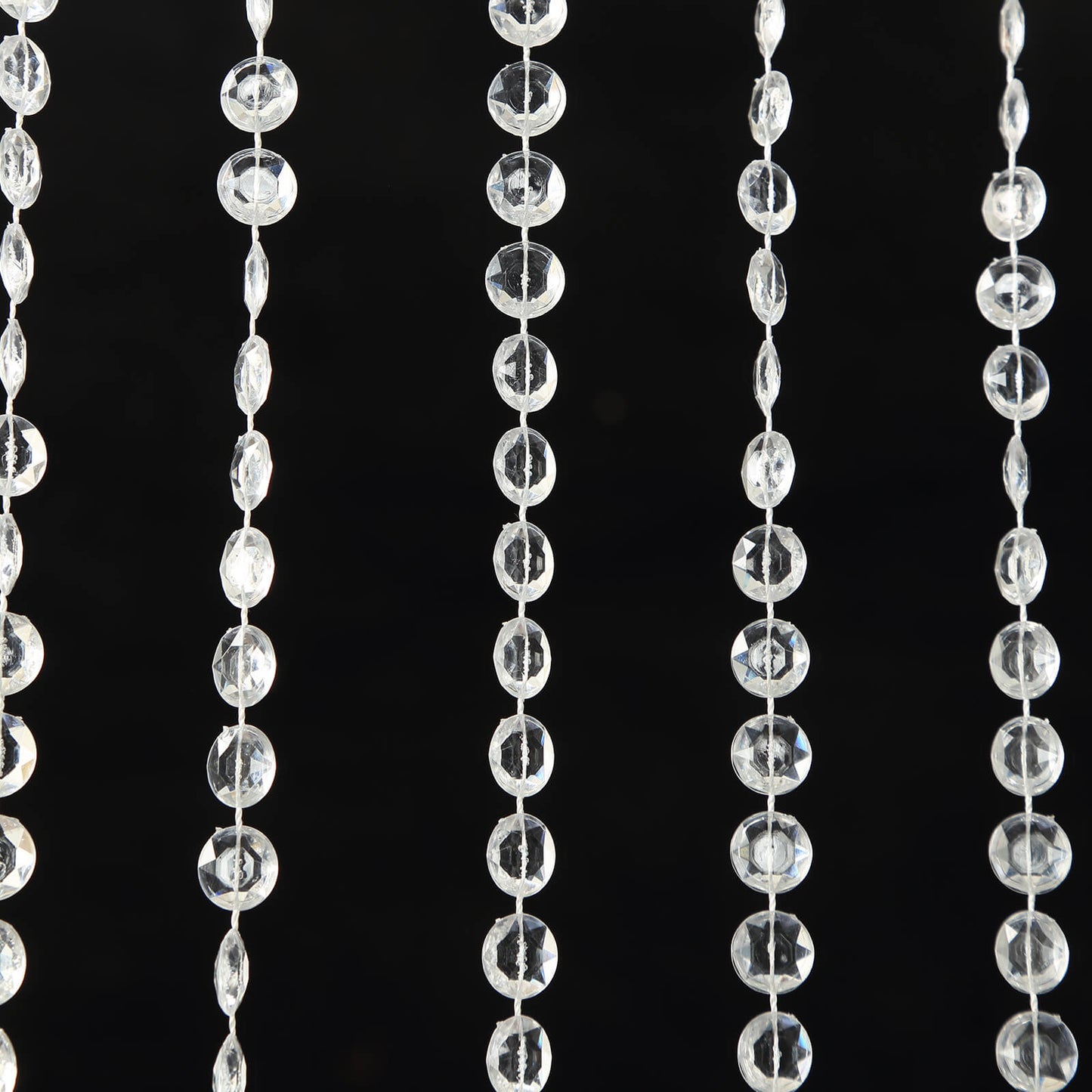 Clear acrylic crystal beaded curtain strands on a black background.