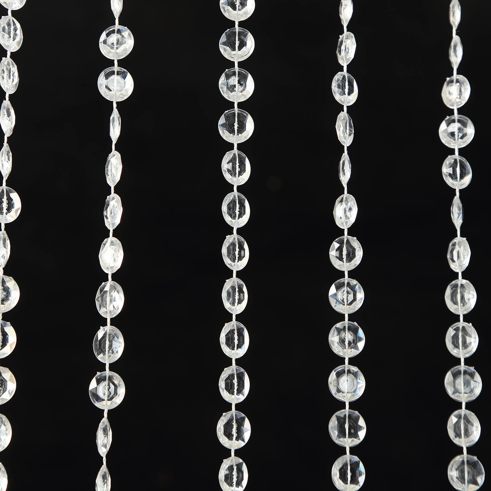 Clear acrylic crystal beaded curtain strands on a black background.