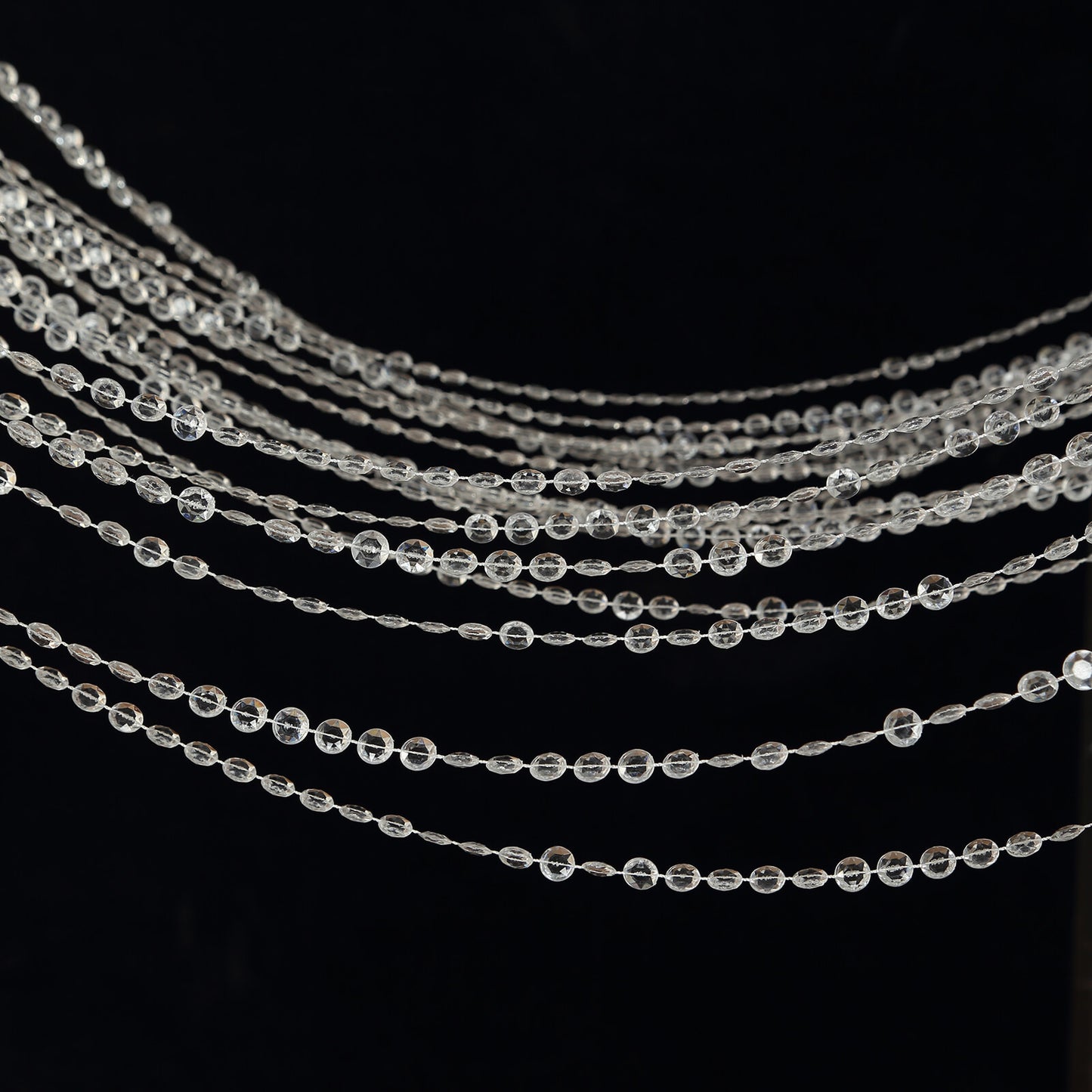 Clear acrylic beaded curtain with diamond cut beads and fabric rod pocket.