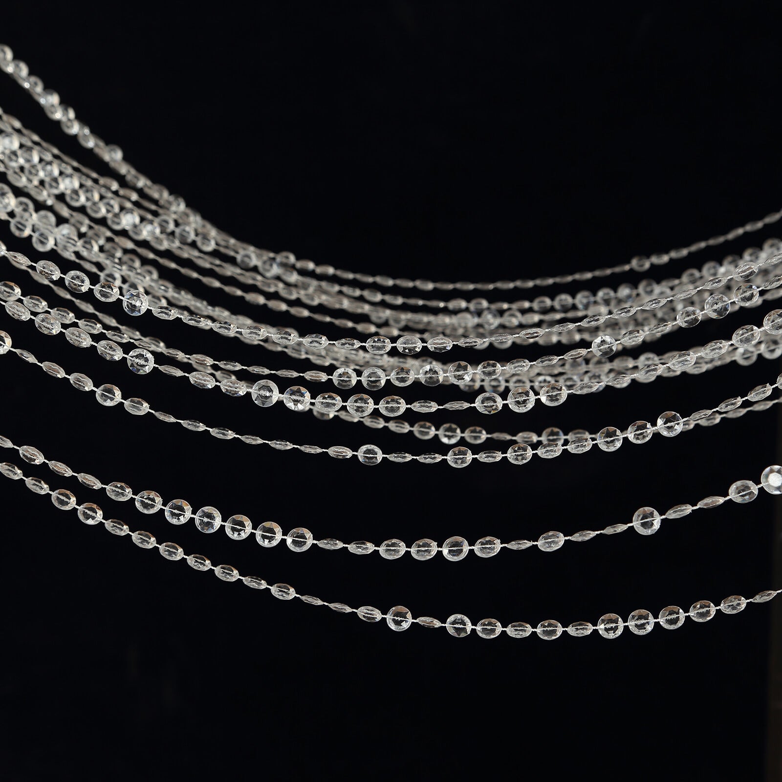 Clear acrylic beaded curtain with diamond cut beads and fabric rod pocket.