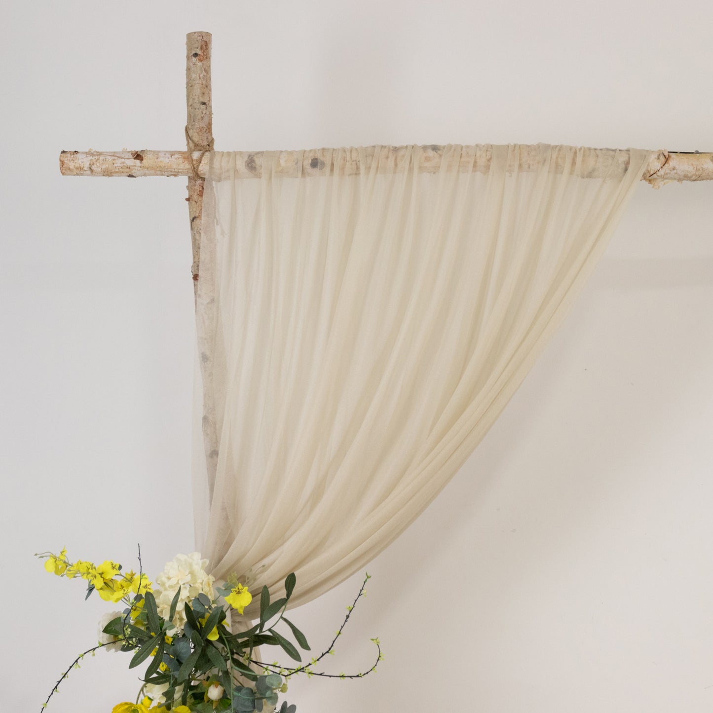 Beige sheer backdrop drape for wedding arch and ceiling decor.