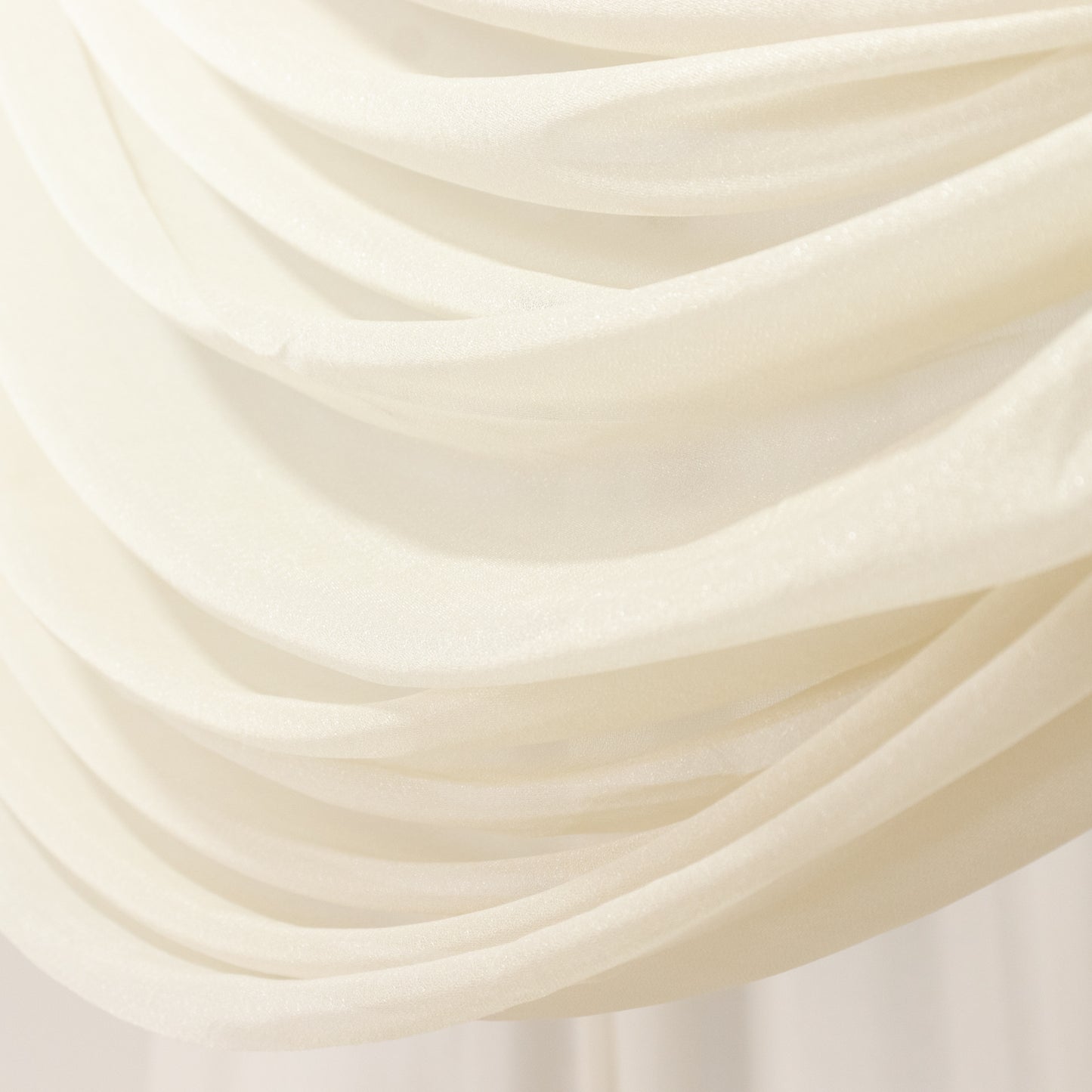 Beige sheer backdrop drape with soft shimmer for wedding decor.