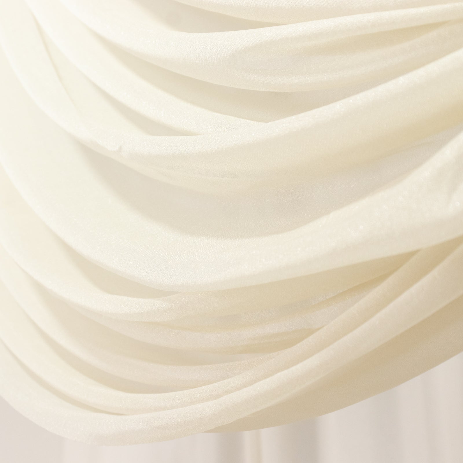 Beige sheer backdrop drape with soft shimmer for wedding decor.