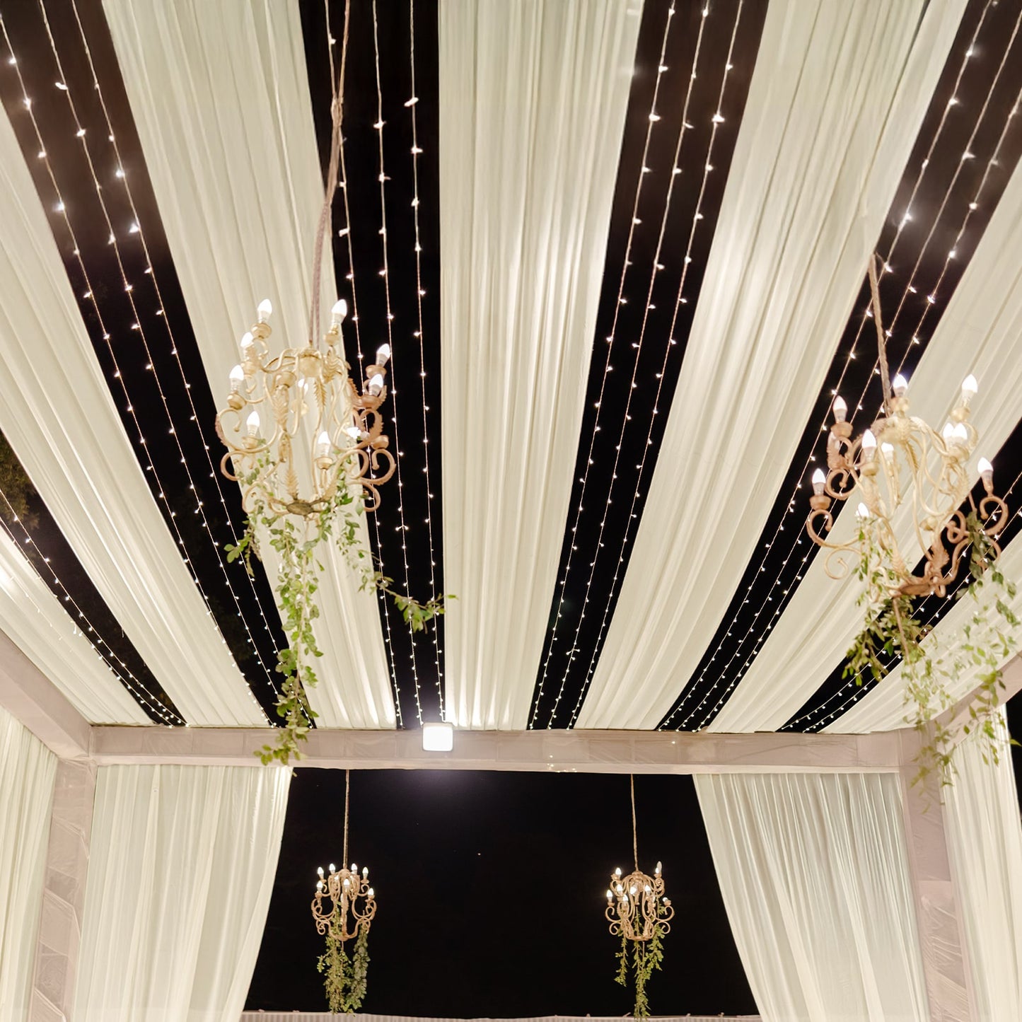 Beige sheer backdrop drape with soft shimmer, ideal for wedding decor.