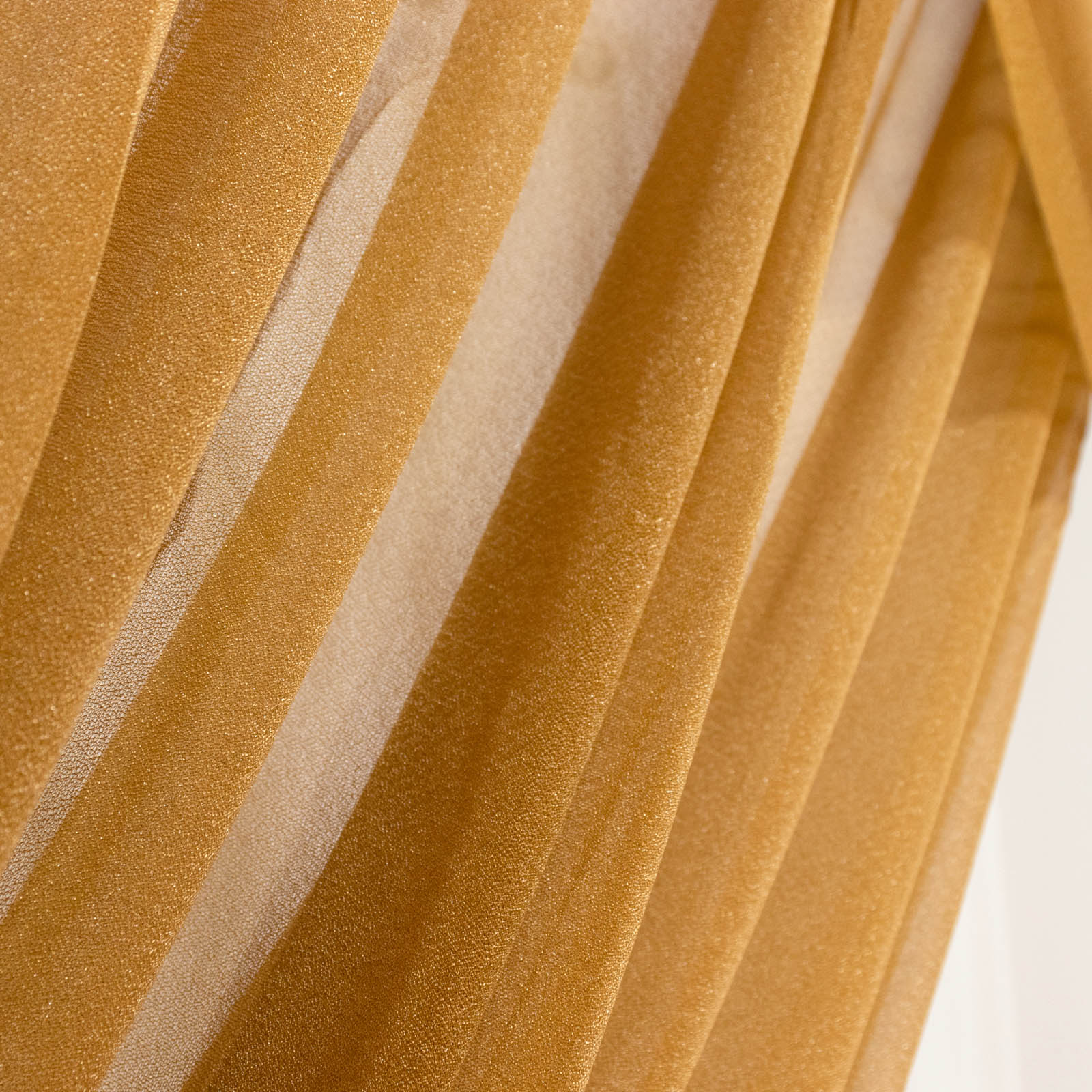 Gold sheer backdrop drape for wedding arch and ceiling decor.