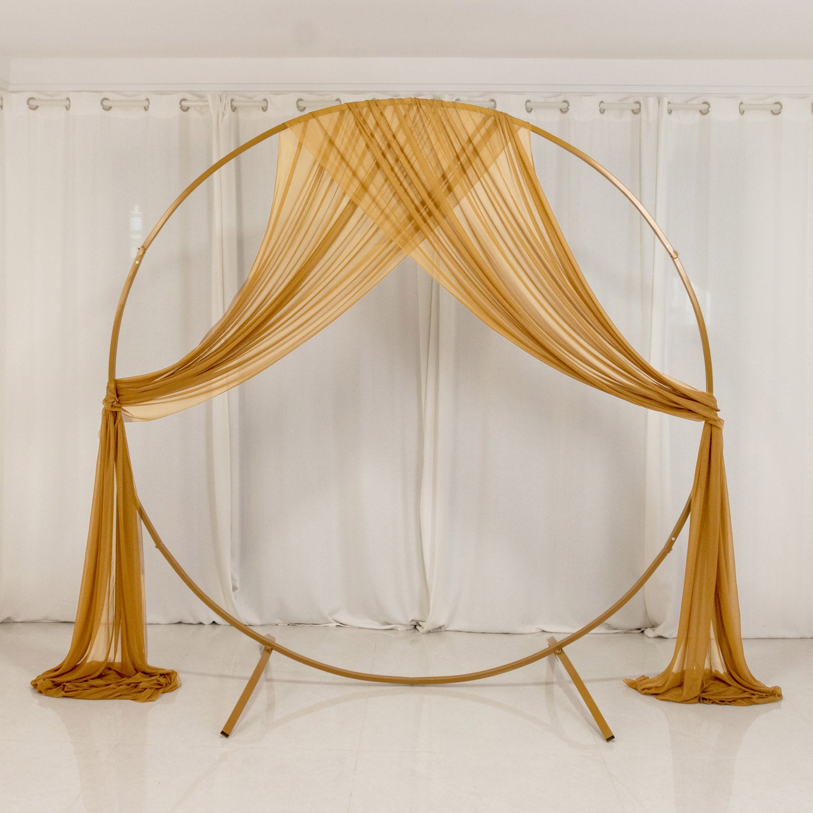 Gold sheer backdrop drape for wedding arch and ceiling decor.