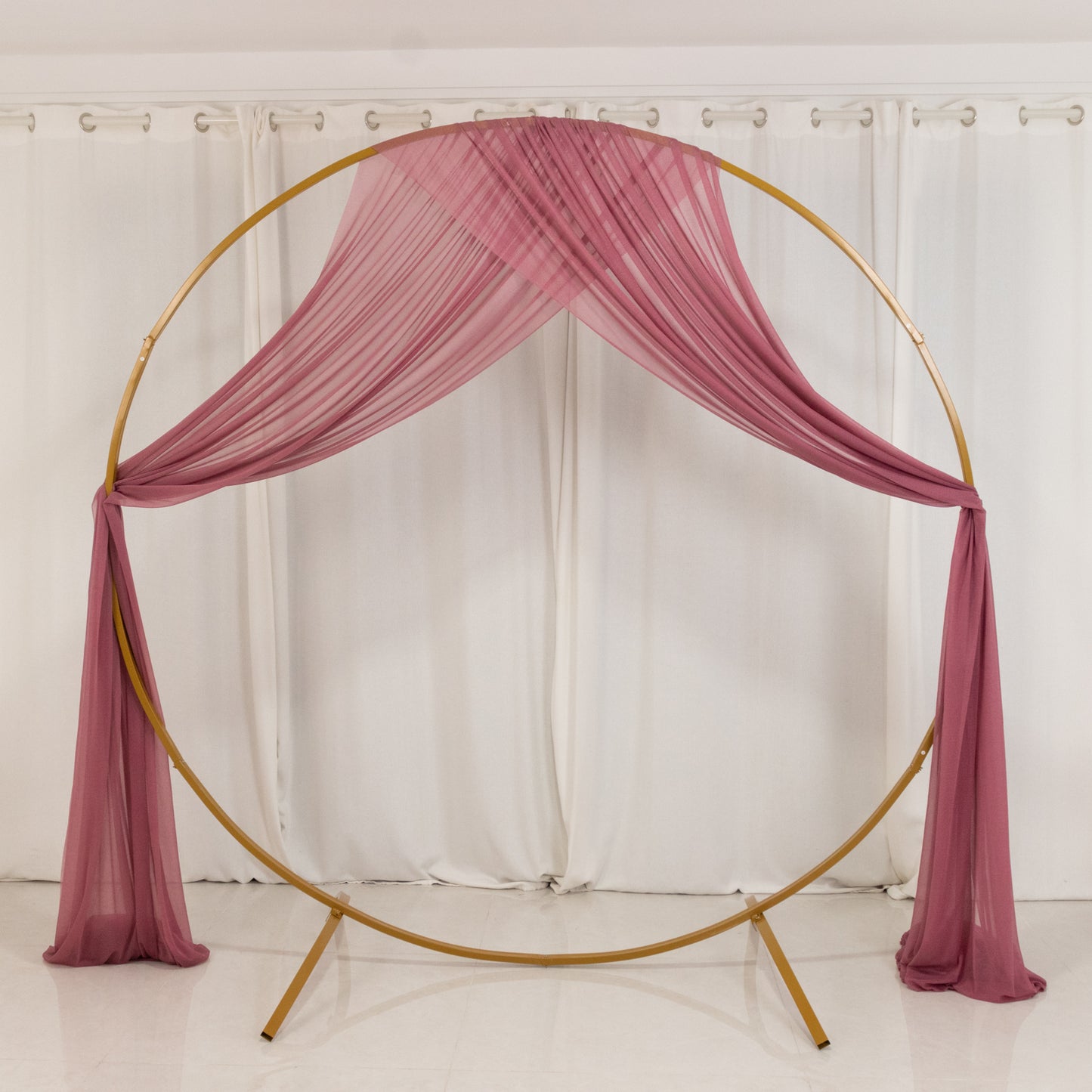 Mauve sheer backdrop drape on a wedding arch with soft shimmer.