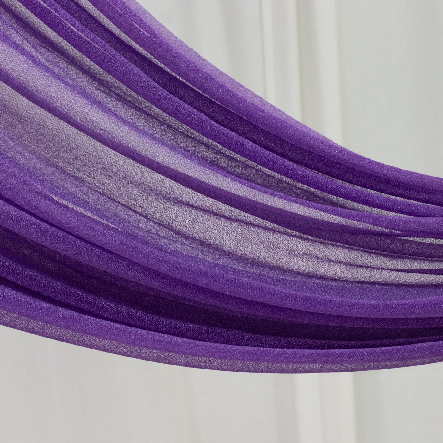 Purple sheer backdrop drape for wedding arch and ceiling decor.
