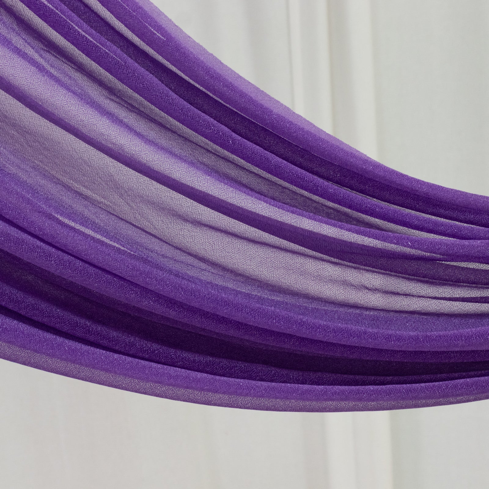 Purple sheer backdrop drape for wedding arch and ceiling decor.