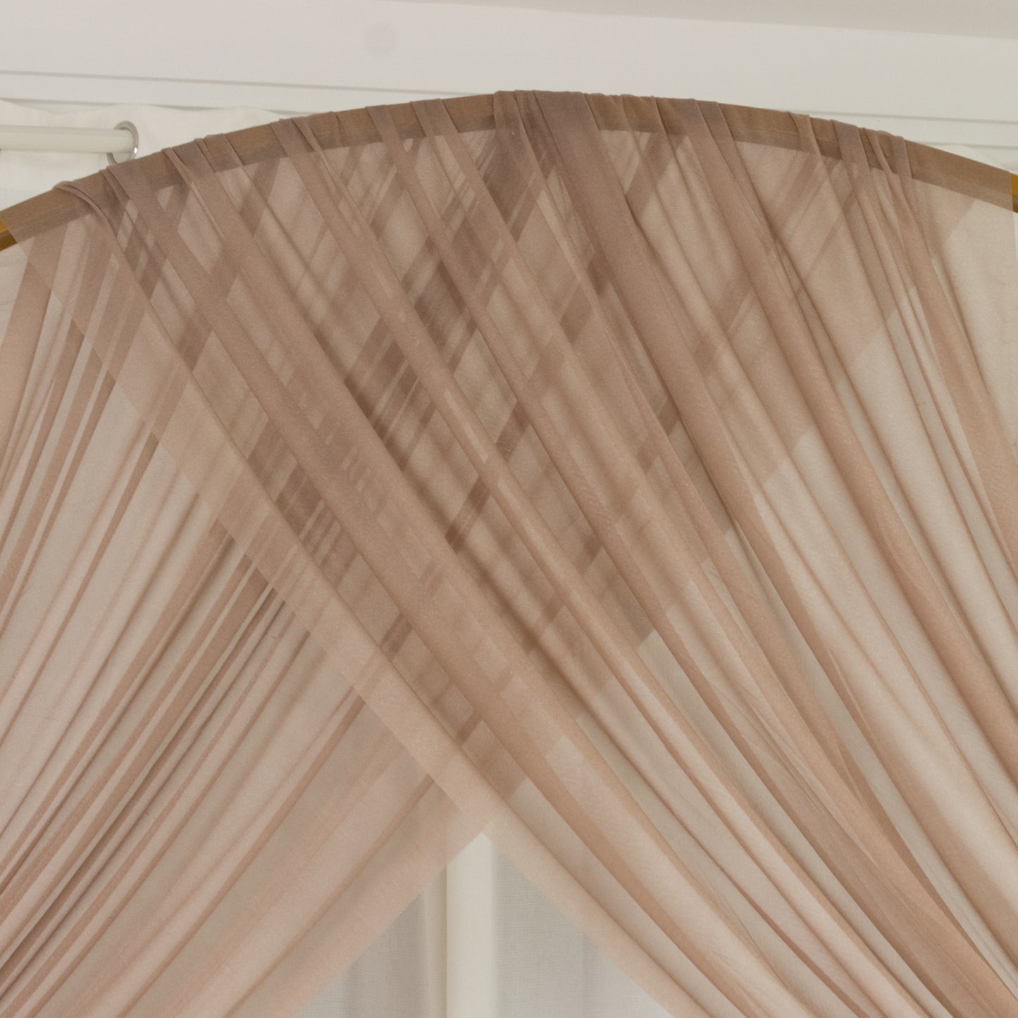 Taupe sheer backdrop drape for wedding arch and ceiling decor.