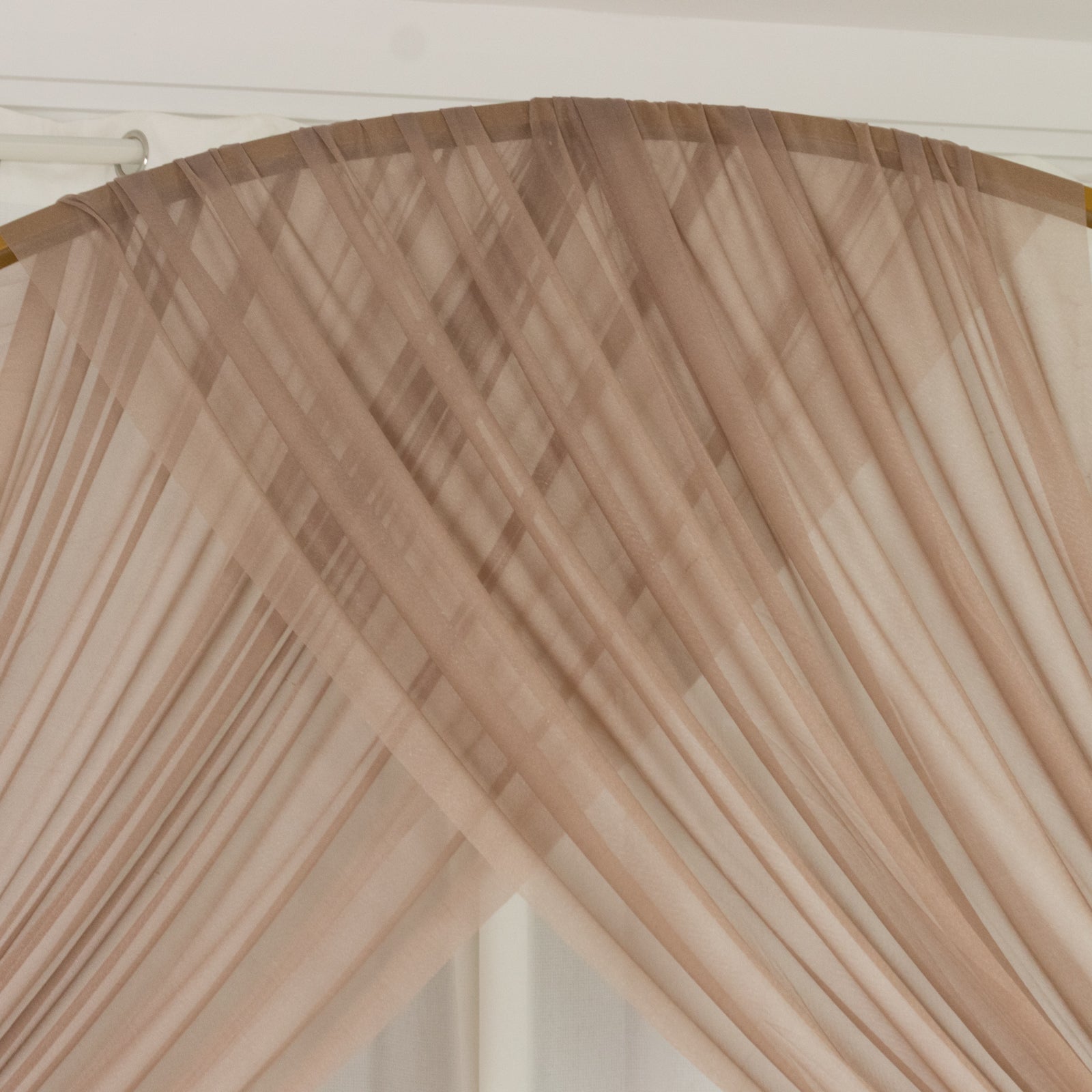 Taupe sheer backdrop drape for wedding arch and ceiling decor.