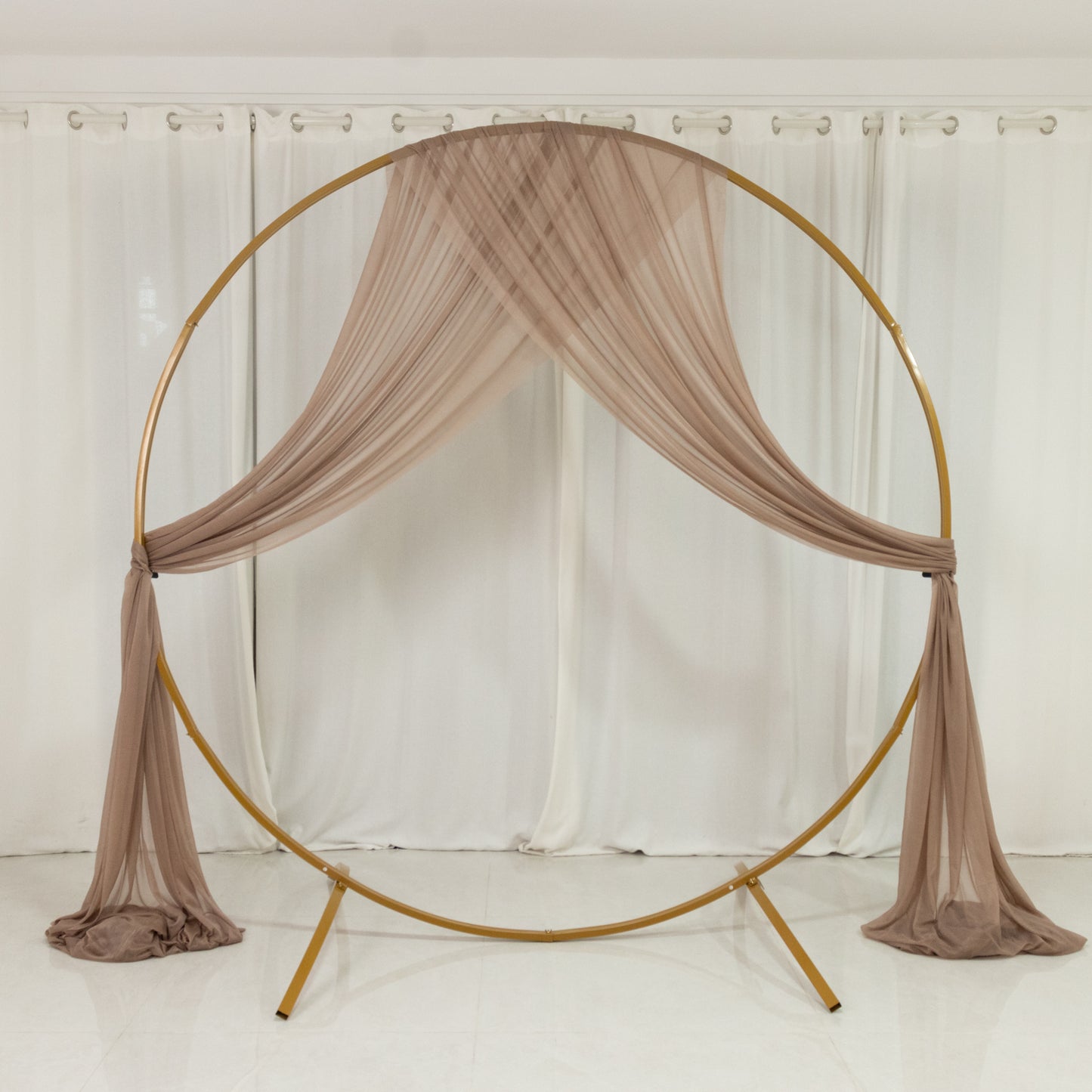 Taupe sheer drape wedding arch with soft shimmer for elegant decor.