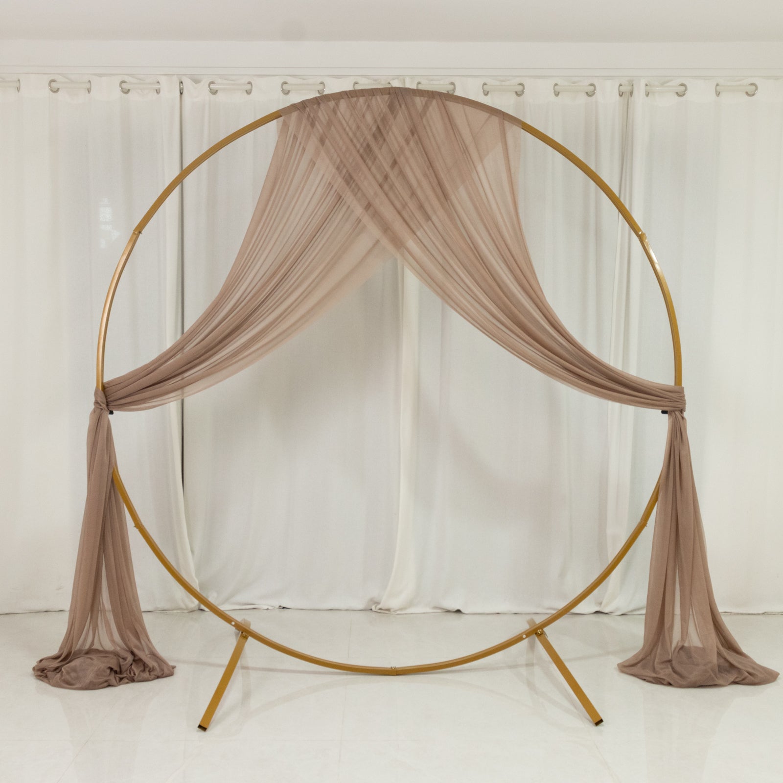 Taupe sheer drape wedding arch with soft shimmer for elegant decor.
