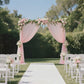 Blush sheer backdrop curtain drape for wedding arch with floral accents.
