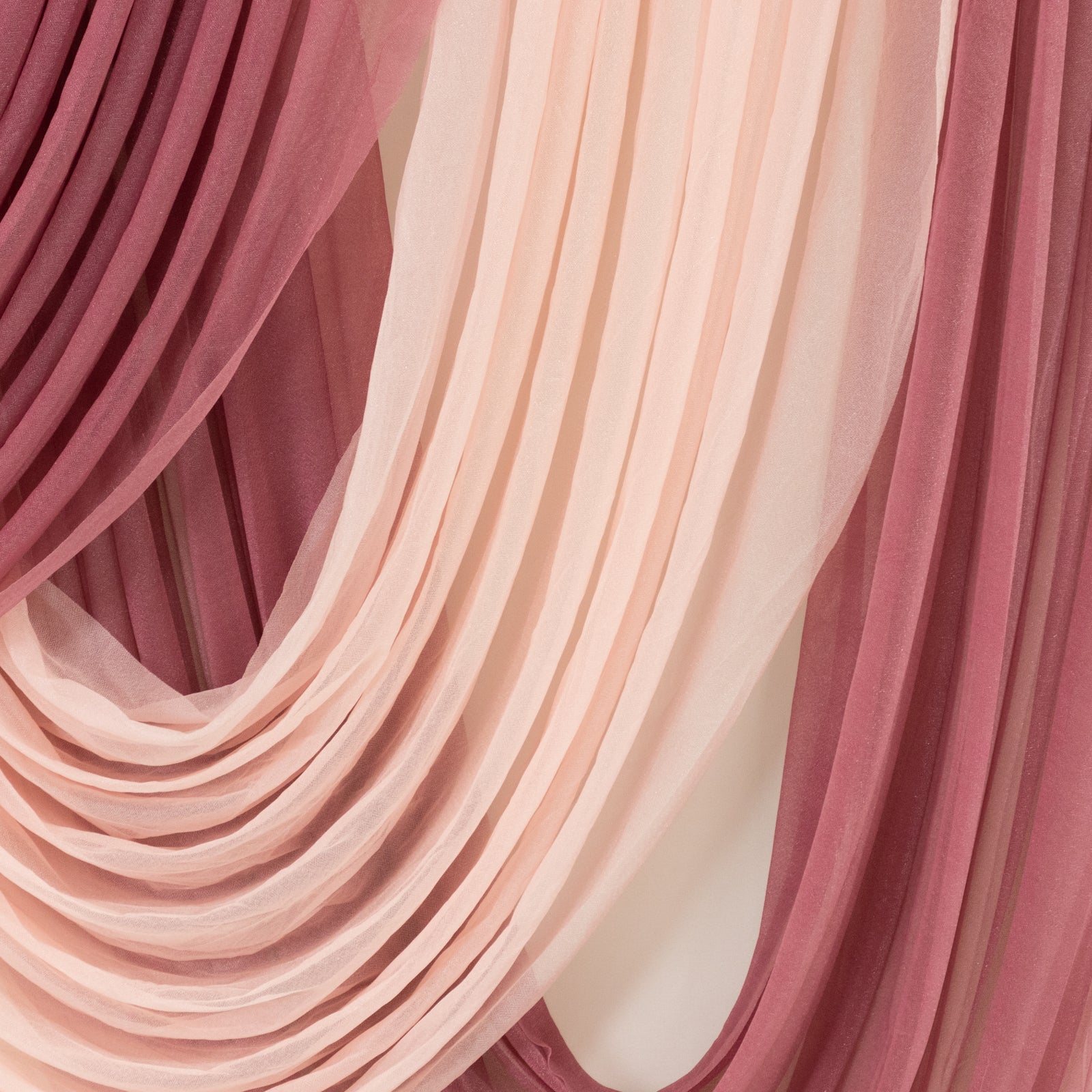 Blush sheer chiffon backdrop valance drapes with curved swag design.