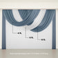 Dusty blue sheer chiffon backdrop drapes with curved swag design.