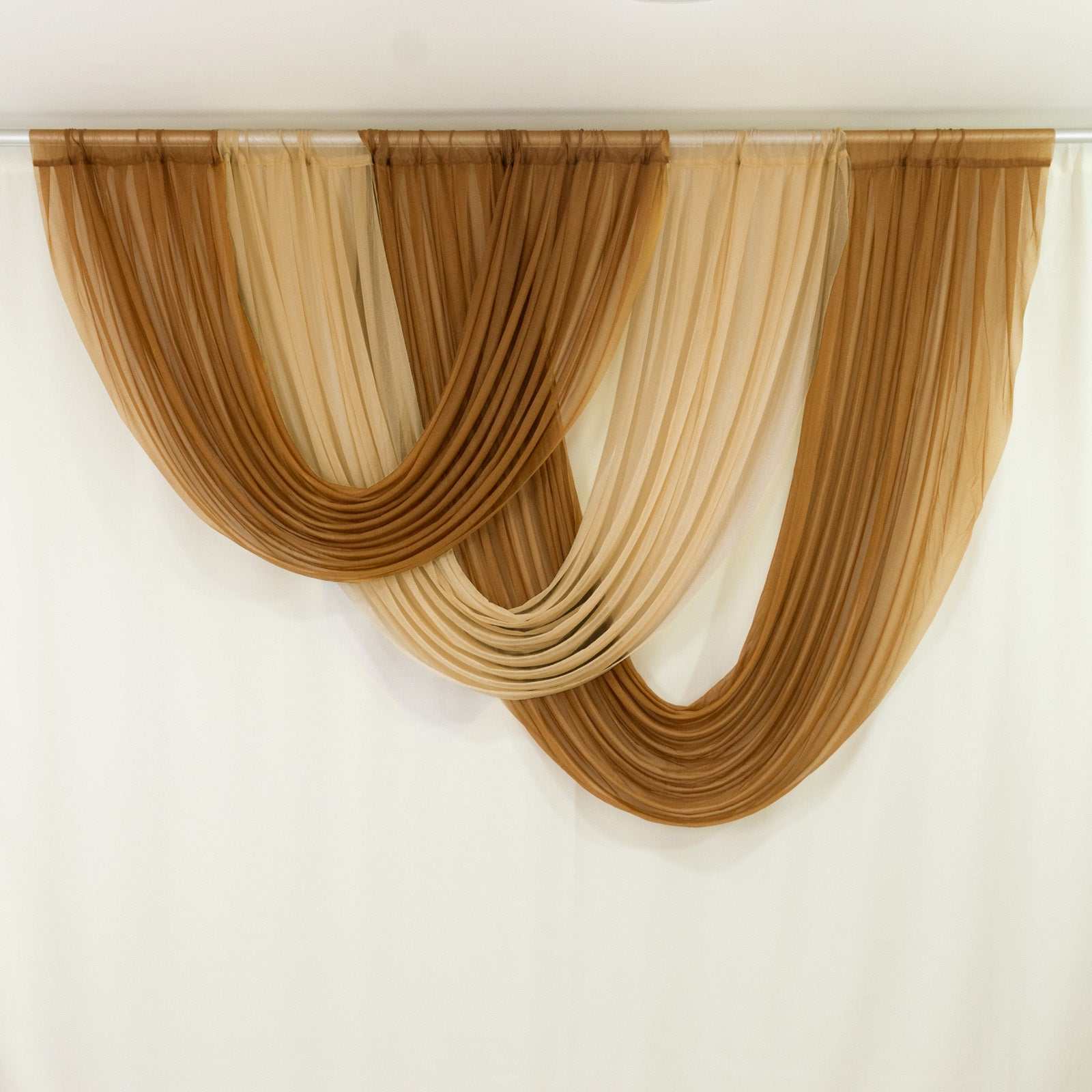 Champagne sheer chiffon backdrop valance drapes with curved swag design.