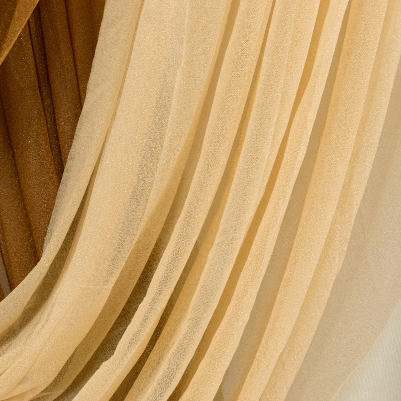 Champagne sheer chiffon backdrop valance drapes with curved swag design.