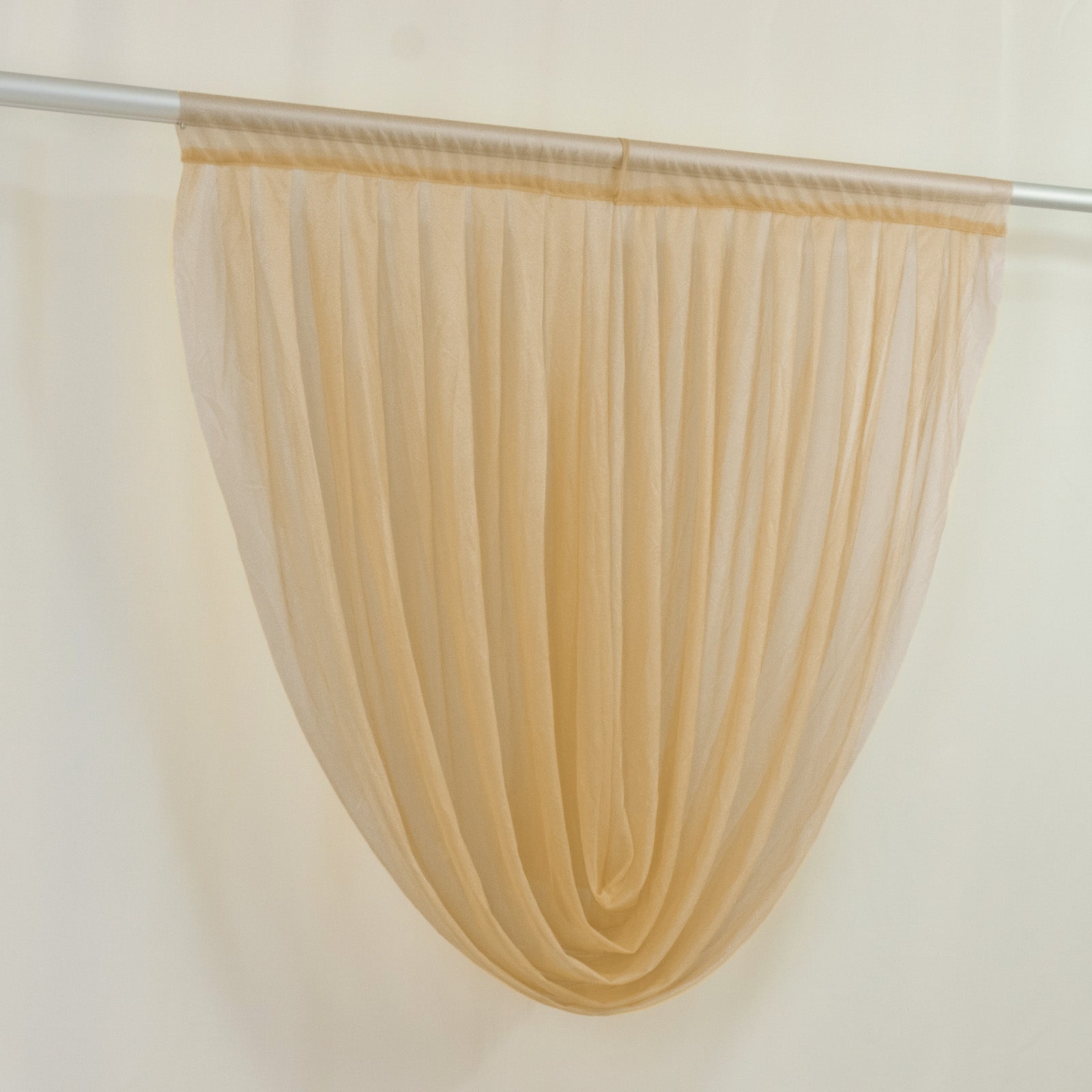 Champagne sheer chiffon backdrop valance drapes hanging elegantly.