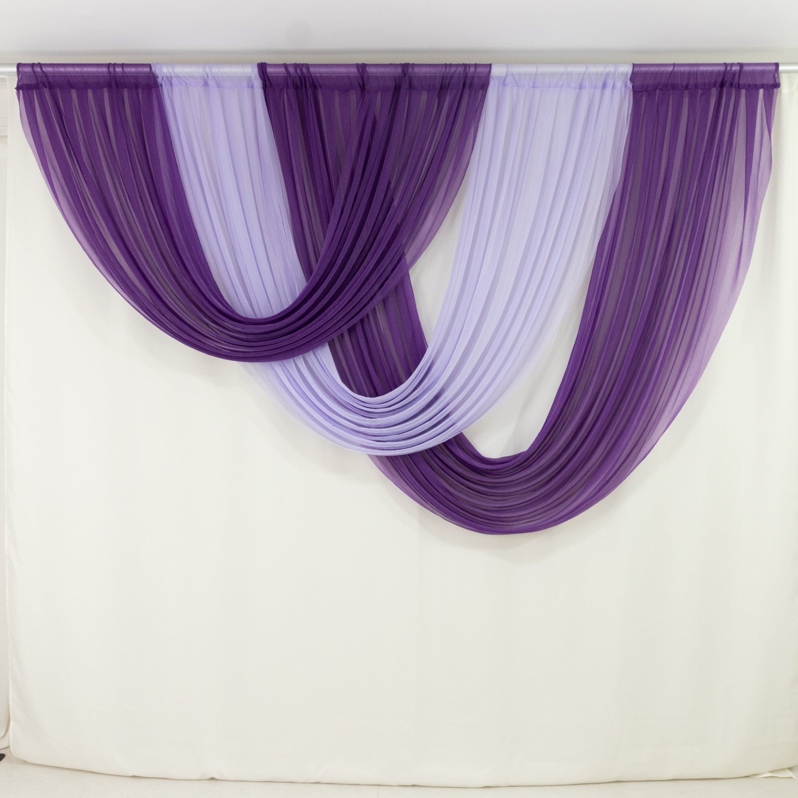 Lavender lilac sheer chiffon backdrop drapes with curved swag design.