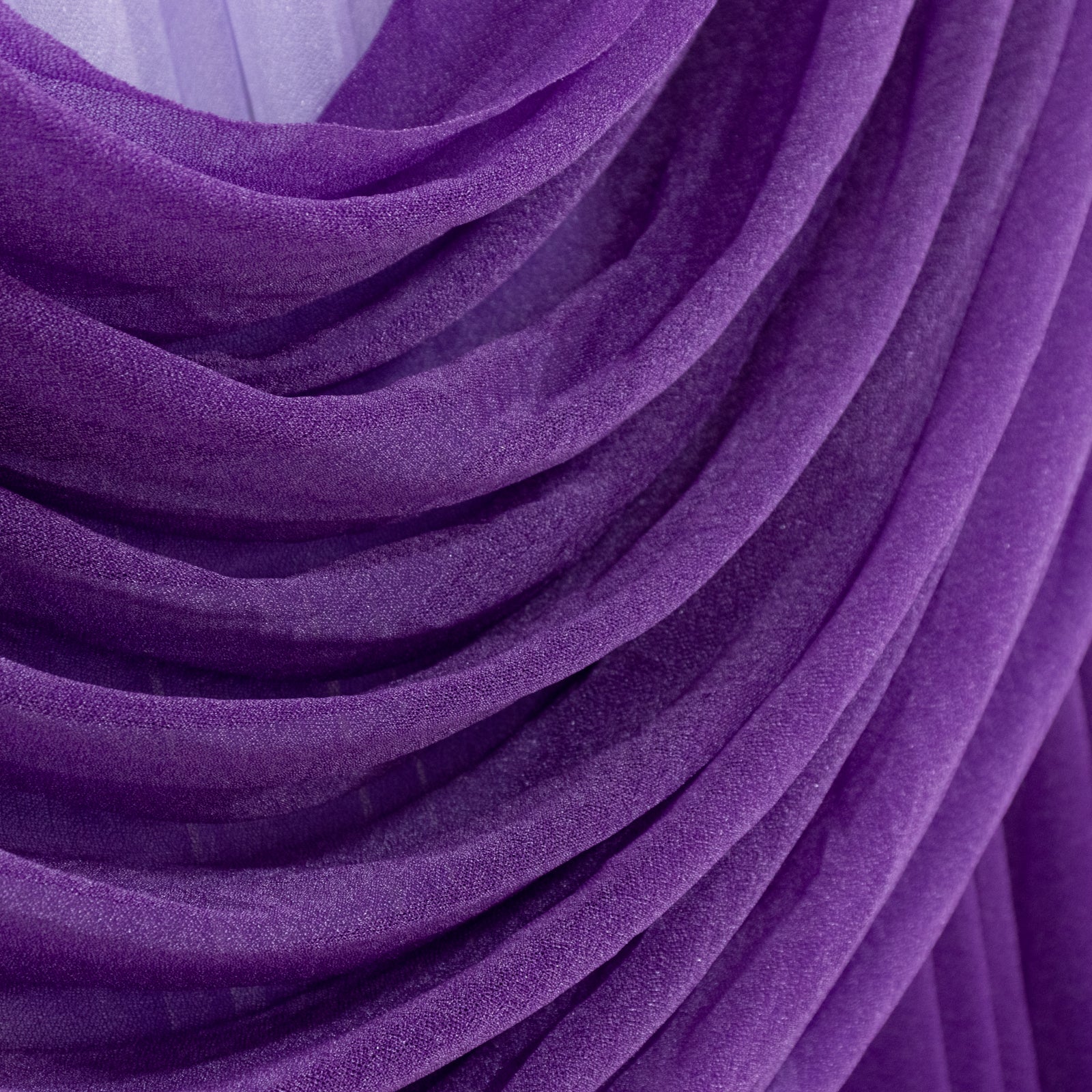 Purple sheer chiffon backdrop drapes with elegant curved swag design.