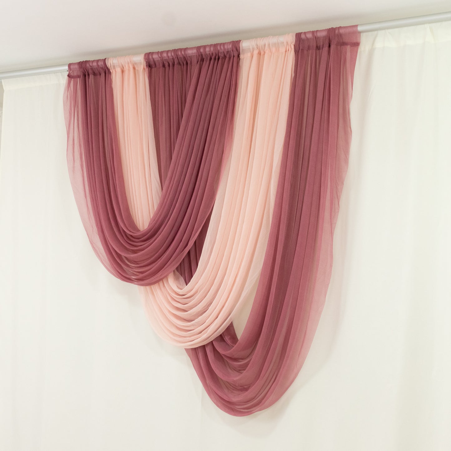 Blush sheer chiffon valance curtain draped elegantly in soft pink and mauve tones.