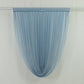 Dusty blue sheer chiffon valance curtain draped on a rod.