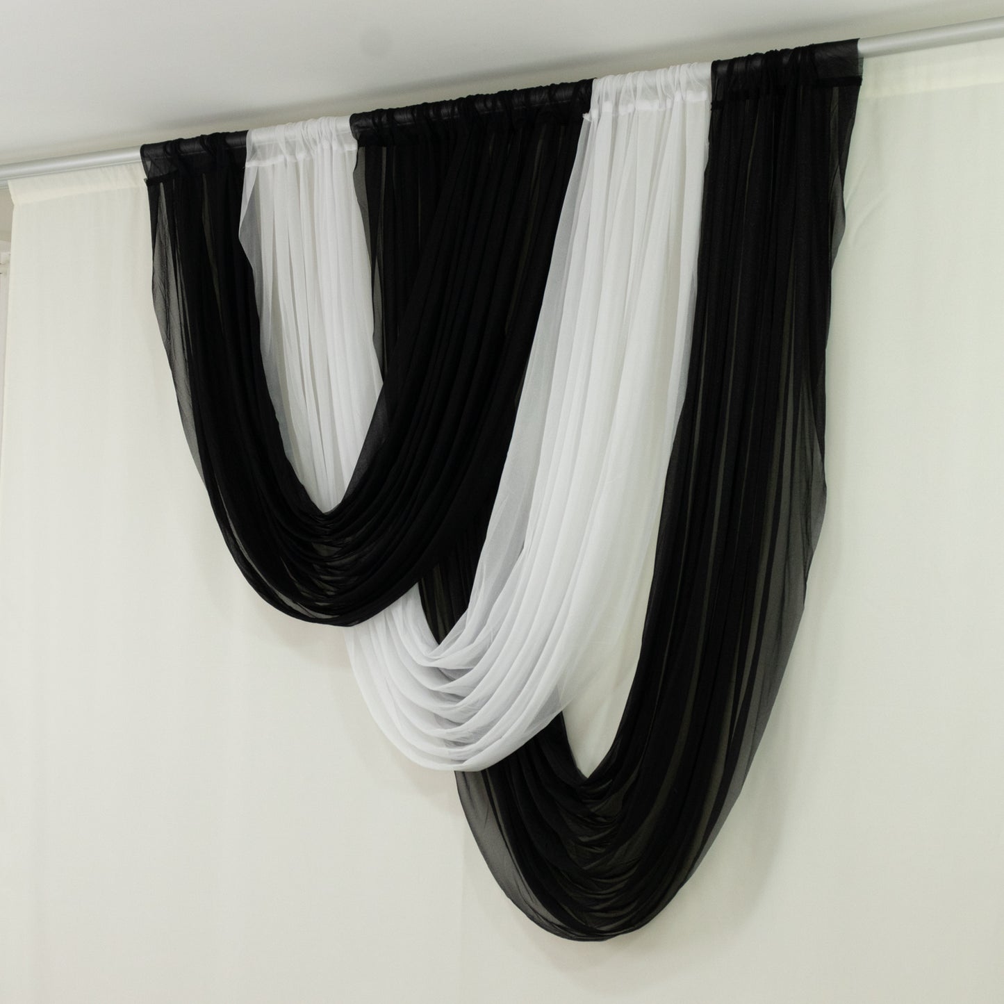 Black sheer chiffon valance curtain draped elegantly over a white backdrop.