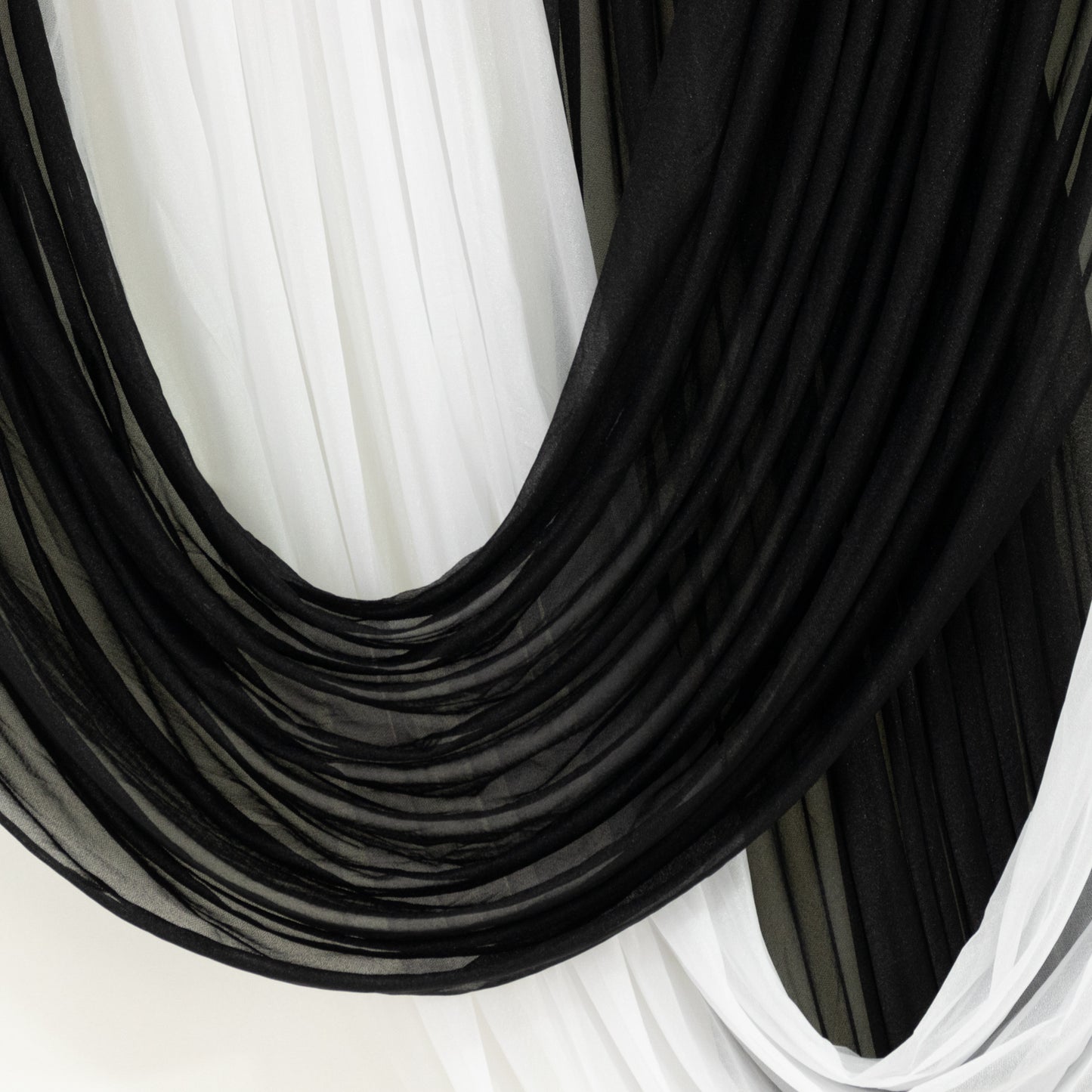 Black sheer chiffon valance curtain draped elegantly for a wedding backdrop.