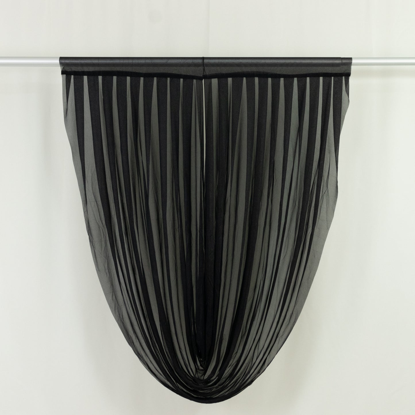 Black sheer chiffon valance curtain draped elegantly on a rod.
