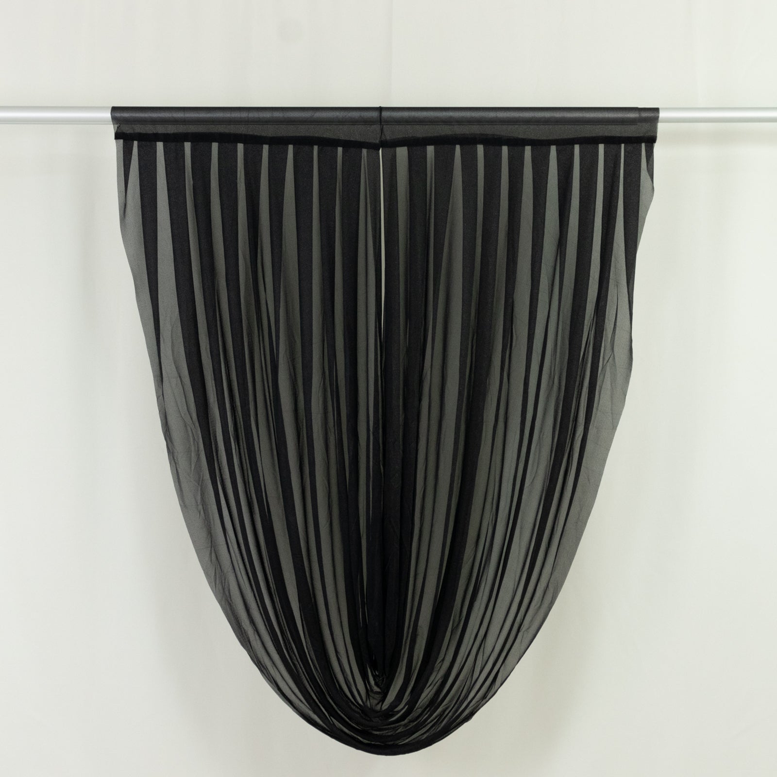 Black sheer chiffon valance curtain draped elegantly on a rod.