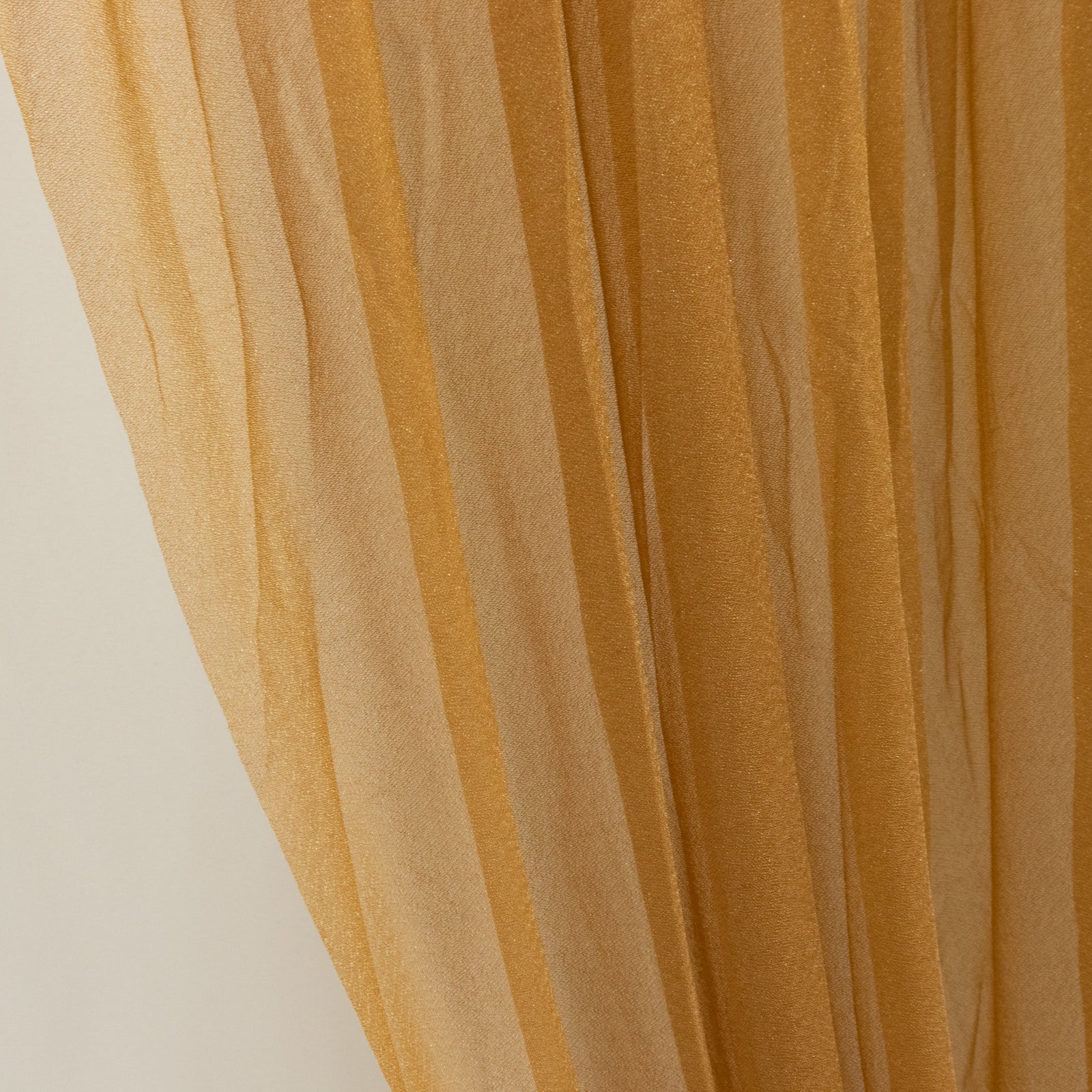 Gold sheer chiffon valance curtain drape for wedding arch backdrop.