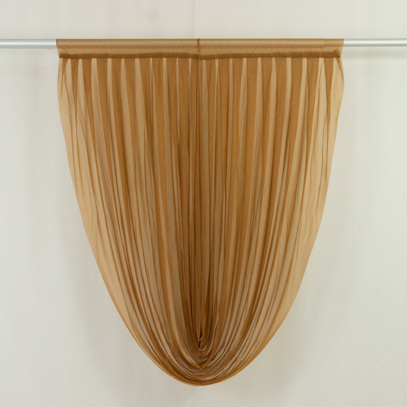 Gold sheer chiffon valance curtain draped elegantly on a rod.