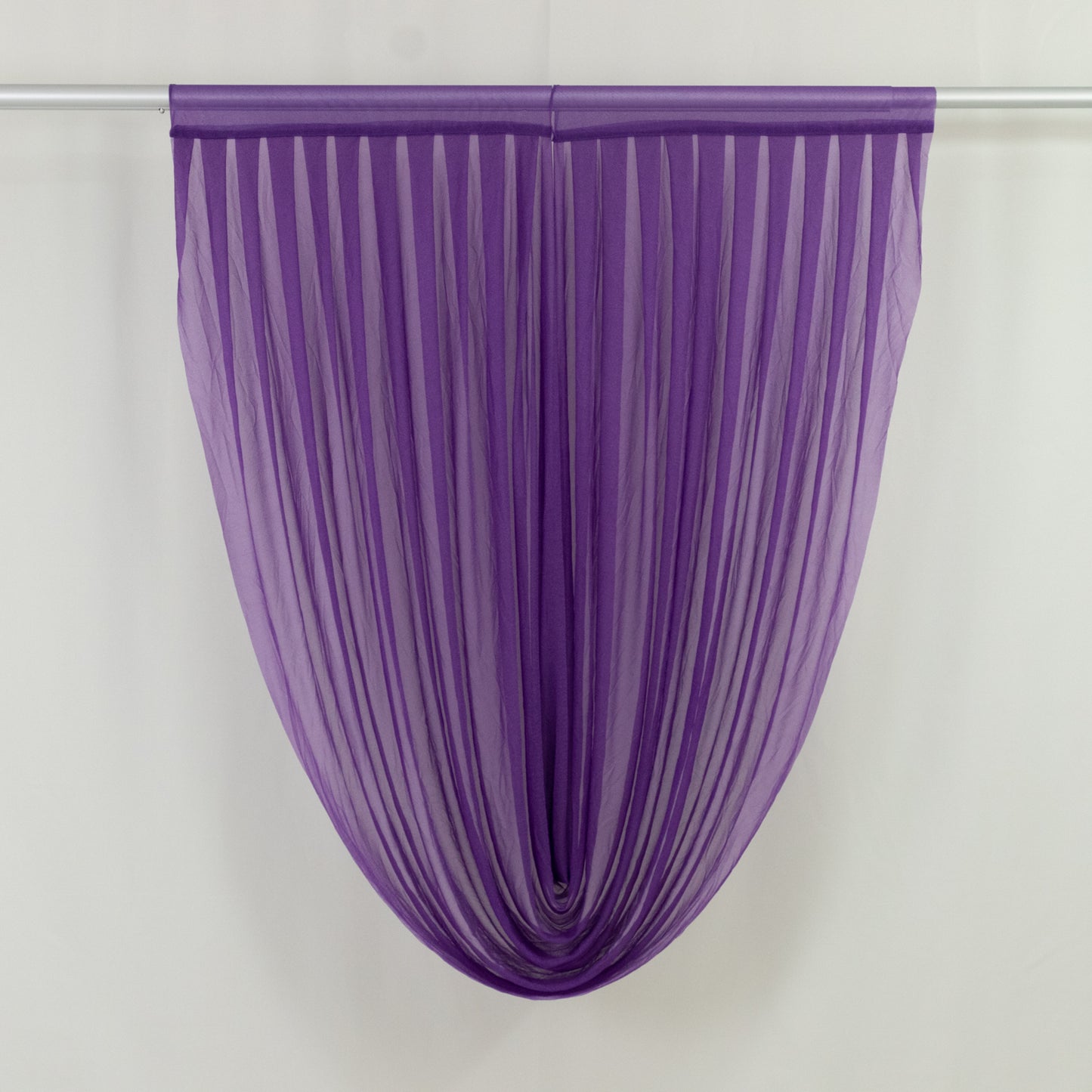 Purple sheer chiffon valance curtain draped on a rod.
