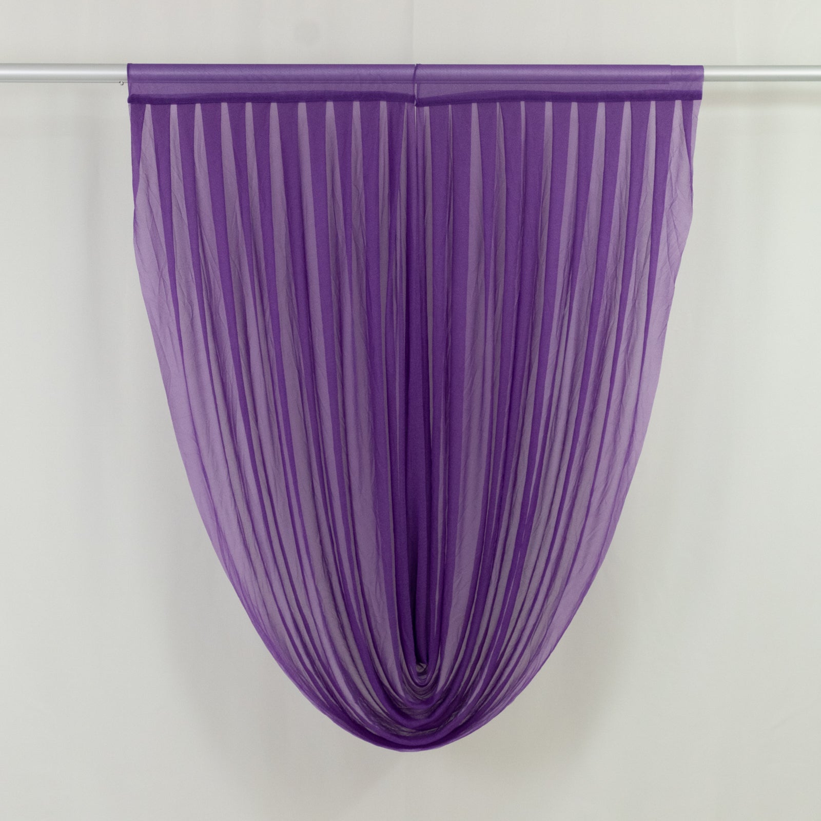 Purple sheer chiffon valance curtain draped on a rod.