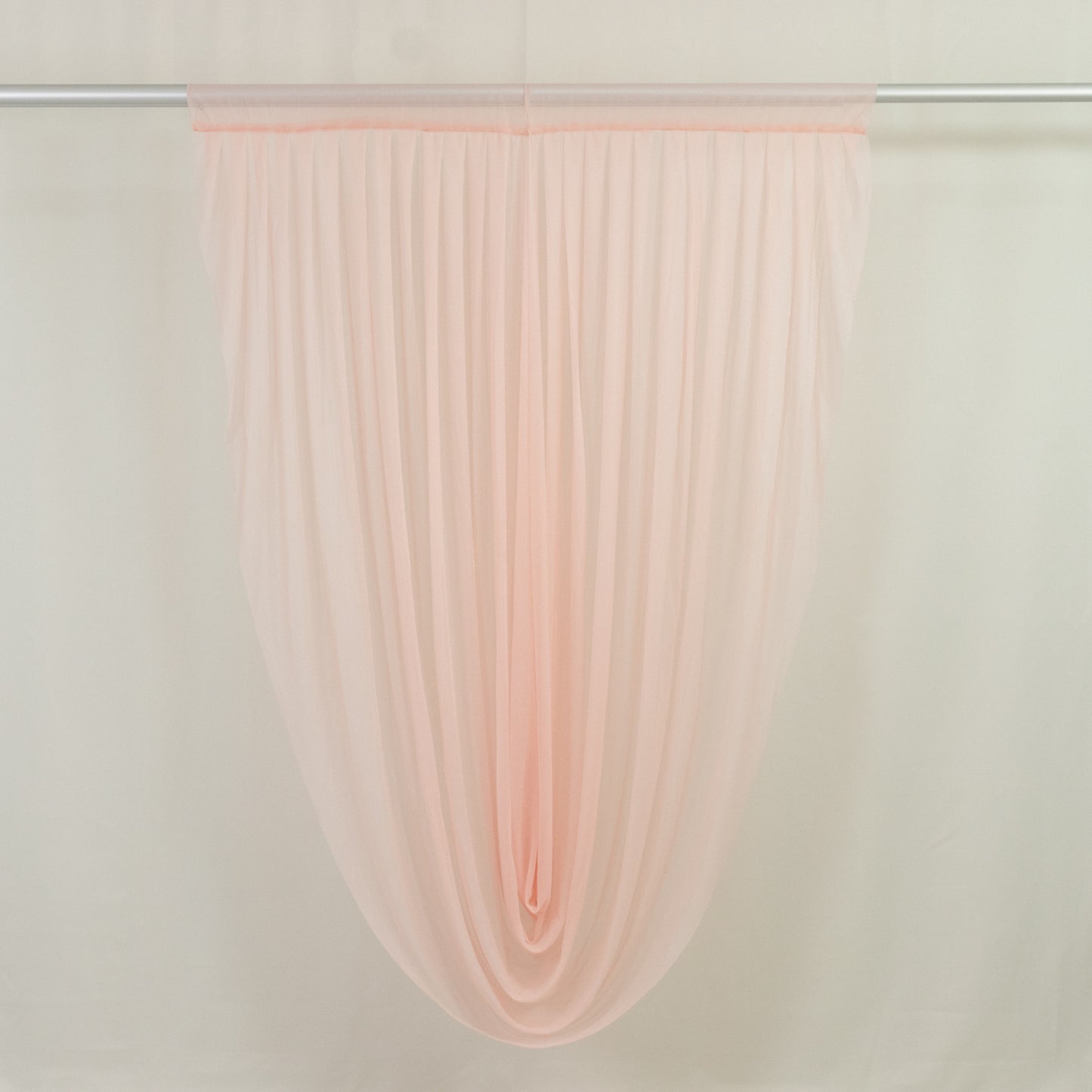 Blush draped sheer fabric for elegant home decor and event styling.