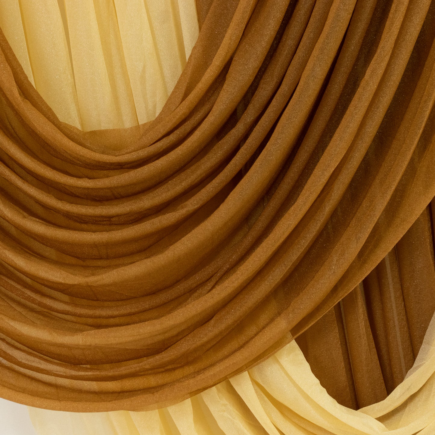 Gold sheer fabric draping with elegant folds and textures.
