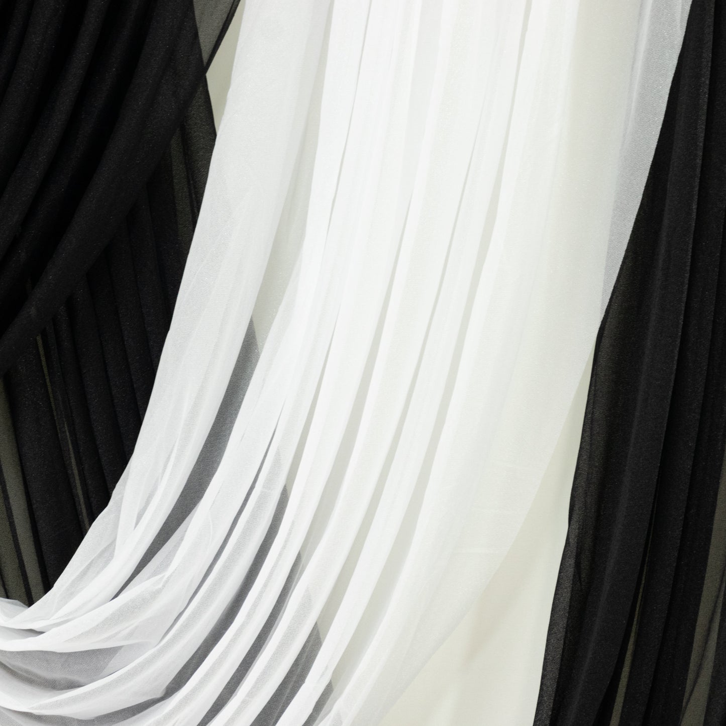 White sheer fabric draped alongside black tulle for elegant decor accents.