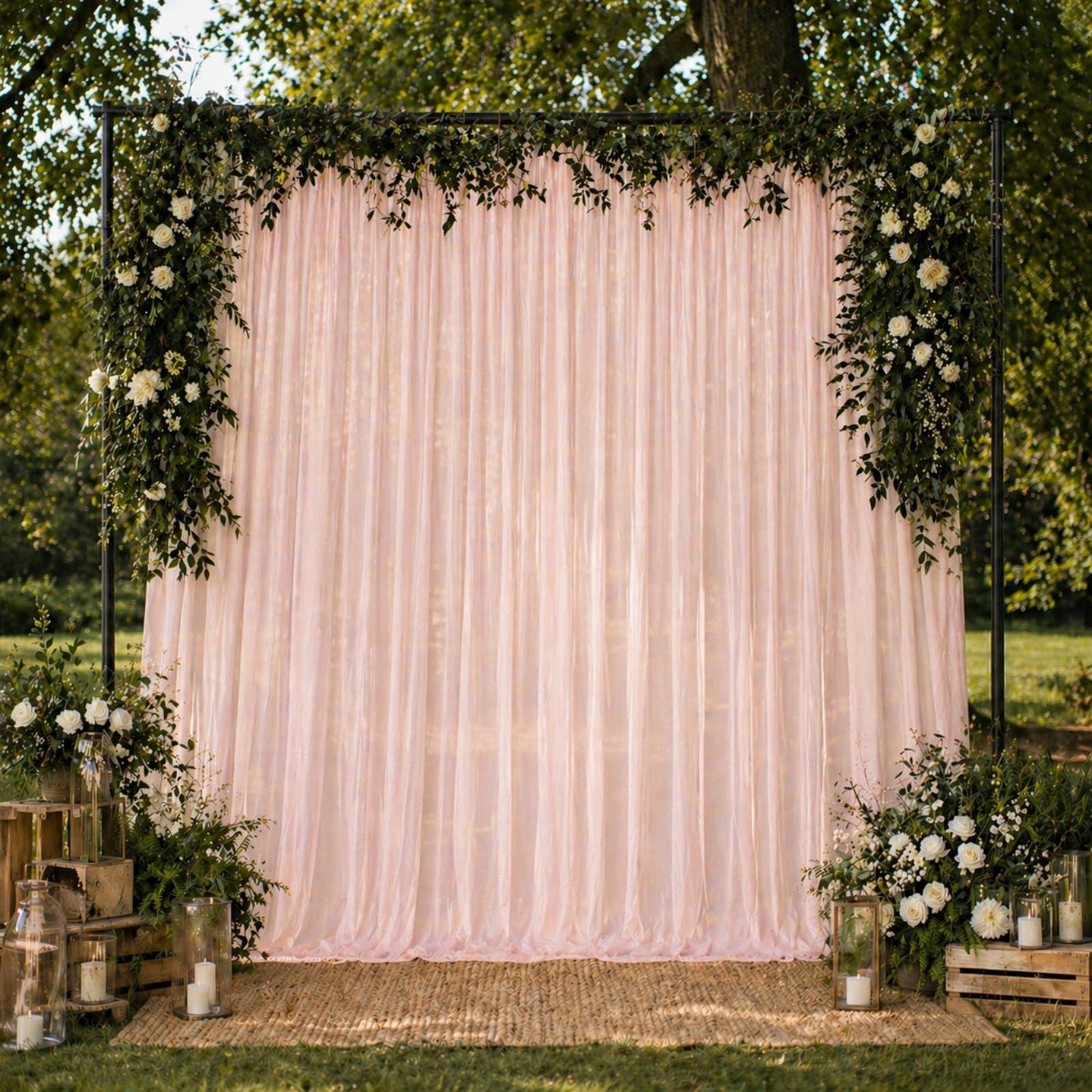 Blush chiffon backdrop curtain panel with floral decor and greenery.