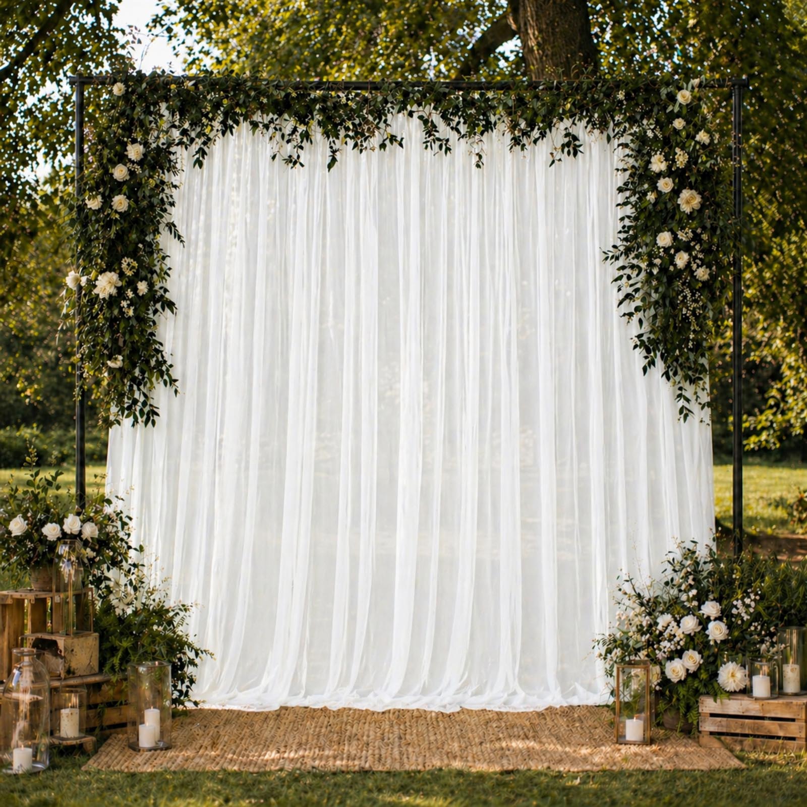 White chiffon backdrop curtain panel with floral decor and greenery.