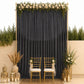 Black chiffon backdrop curtain panel with elegant floral decor and gold chairs.
