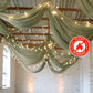 Sage green chiffon curtain panel draping with lights, flame resistant backdrop.