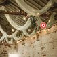 Sage green chiffon curtain panel draping with fairy lights and greenery.