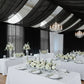 Black chiffon curtain panel drape creating an elegant backdrop in a white and floral setting.