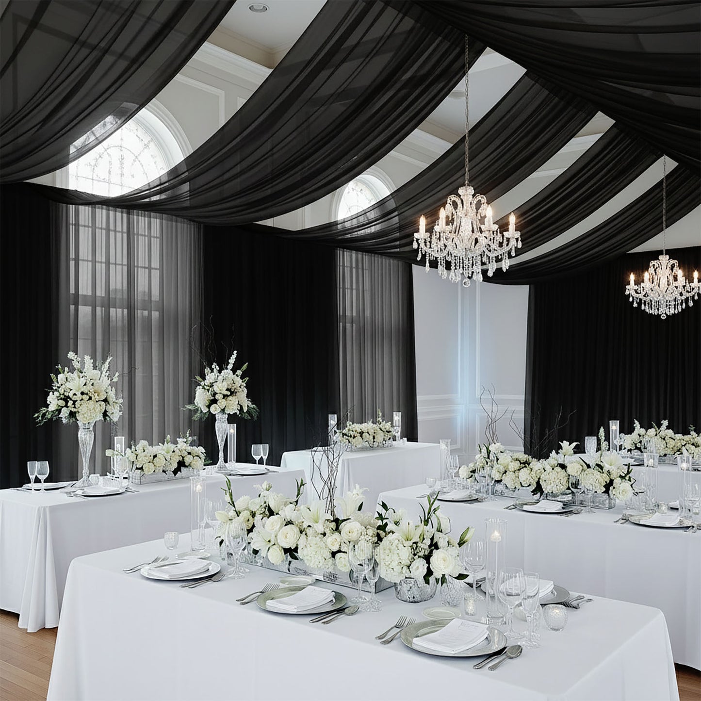 Black chiffon curtain panel drape creating an elegant backdrop in a white and floral setting.